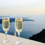 Two champaign glasses on balcony edge overlooking ocean