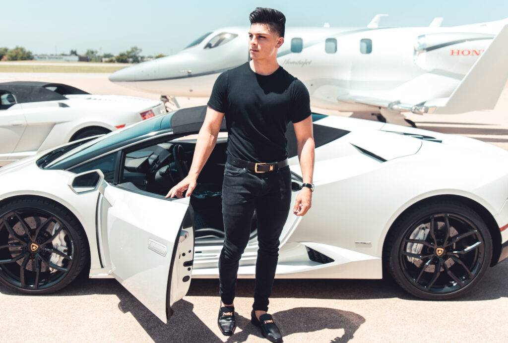 Man with getting out of white sports car near a private jet