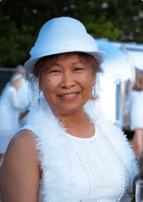 Jacqueline Tai, Founder of Enable My Dreams wearing white had and white dress with fuzzy scarf